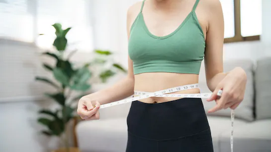 Person celebrating weight loss success with healthcare professional